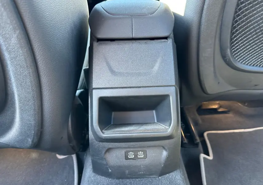 Gros plan sur l'accoudoir central arrière noir de la BMW Série 1 F40 avec prises USB visibles au bas.