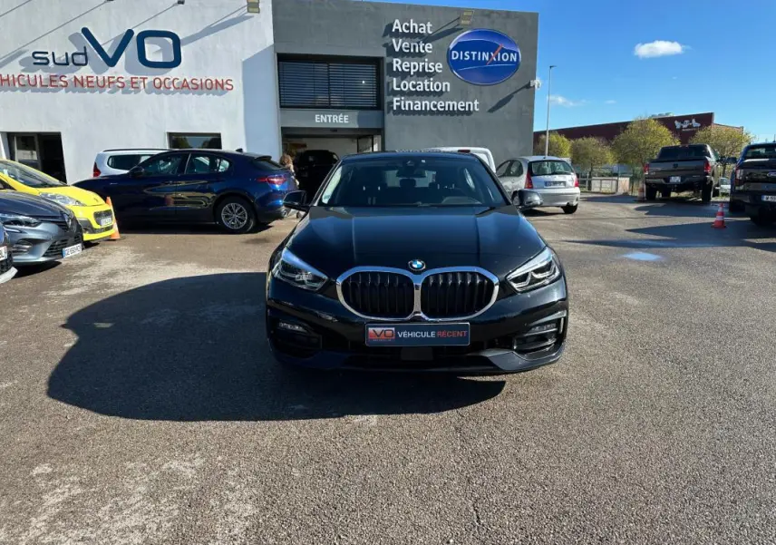 BMW Série 1 F40 118d noire vue de face, avec calandre double haricot et phares LED distinctifs.