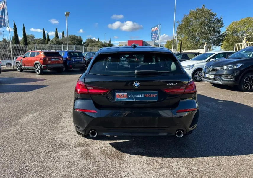 Vue arrière d'une BMW Série 1 noire F40 118d avec double sortie d'échappement et feux arrière LED.