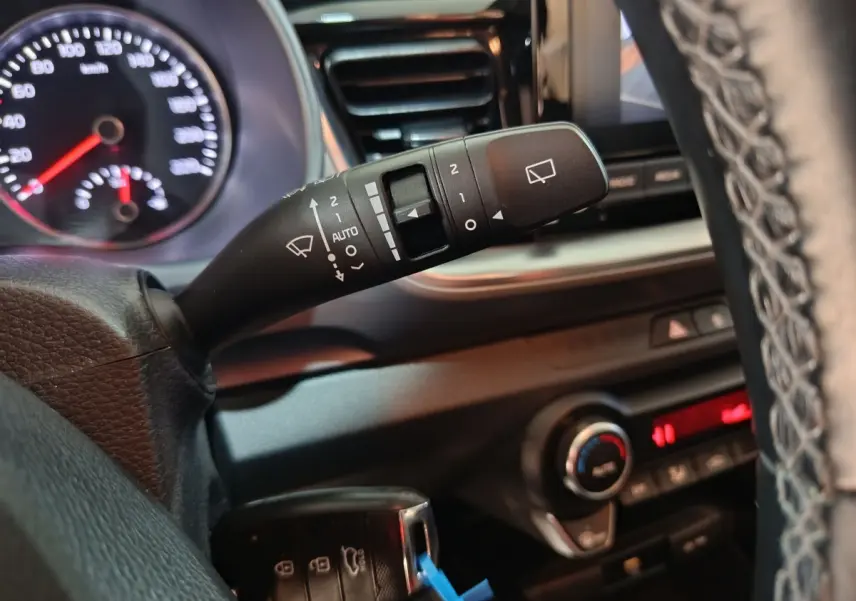 Gros plan sur la commande d’essuie-glace à gauche du volant dans l’habitacle du Kia Stonic gris clair 2022.