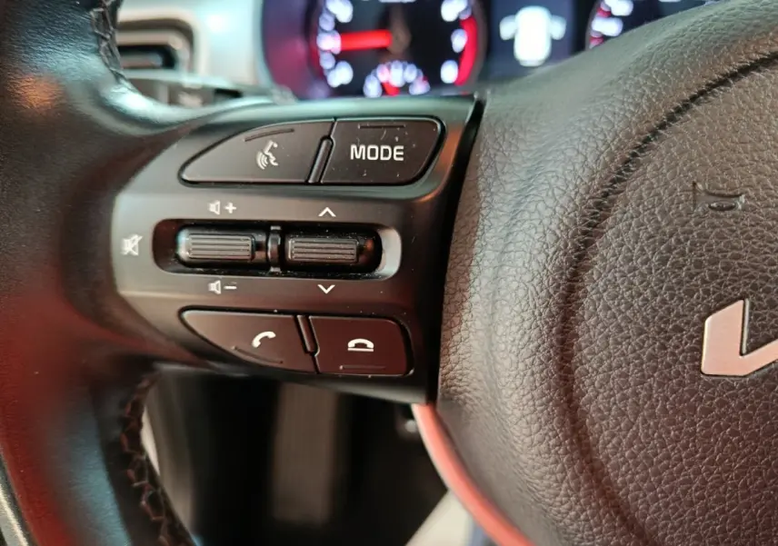 Gros plan sur la partie gauche du volant noir du KIA Stonic 2022 avec commandes audio et téléphone visibles.