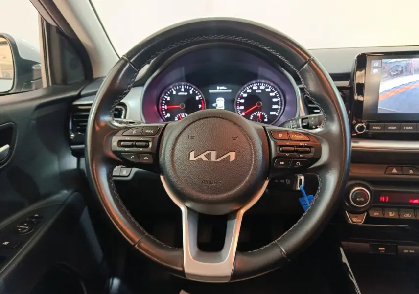 Vue intérieure centrée sur le volant noir du Kia Stonic 2022 avec tableau de bord et écran tactile visible à droite.