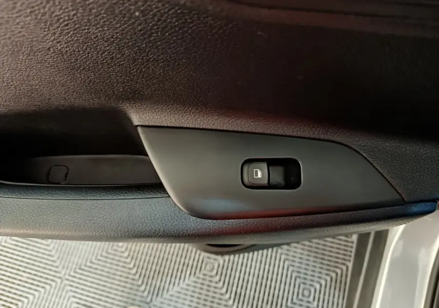 Gros plan sur le bouton de verrouillage centralisé sur la porte côté conducteur d'un KIA Stonic gris clair 2022.