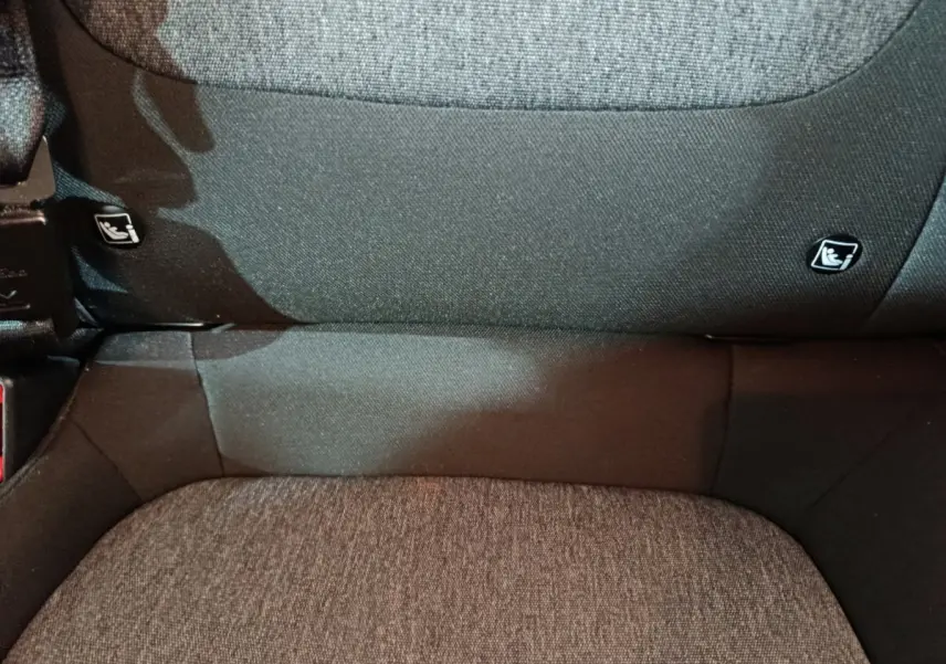 Gros plan sur la banquette arrière en tissu gris foncé du Kia Stonic 2022, avec fixation Isofix visible.