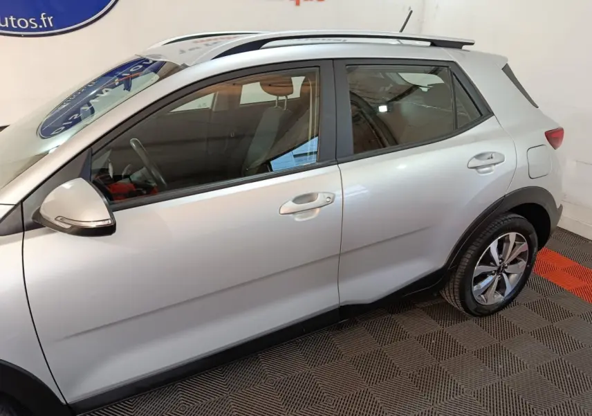 Vue de profil côté droit du KIA STONIC gris clair 2022, mettant en valeur les jantes alliage et les barres de toit.