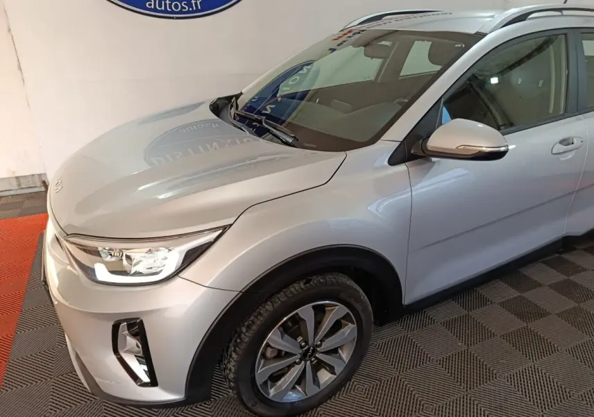 Vue 3/4 avant droit d'un KIA STONIC gris clair 2022 avec phares LED et jantes alliage distinctives.