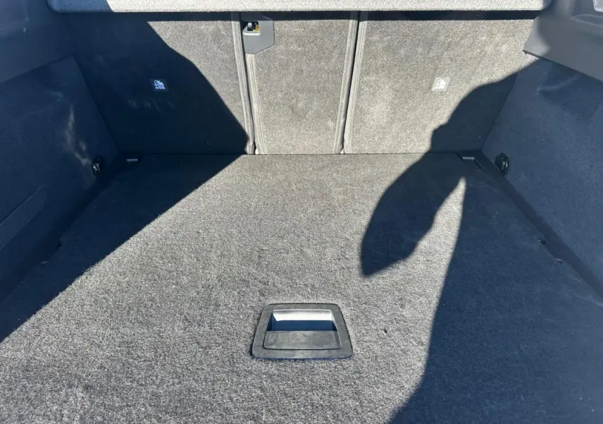 Coffre spacieux et vide du Peugeot 3008 Hybrid blanc, vue intérieure depuis l'ouverture arrière.