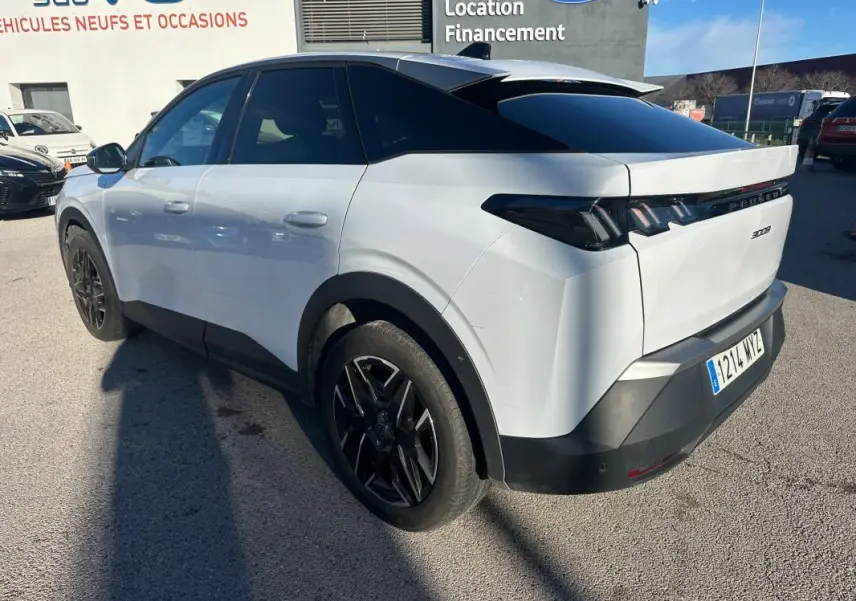 Vue 3/4 arrière droite du Peugeot 3008 Hybrid blanc avec jantes alliage noires de 19 pouces, vitres teintées et feux arrière LED.