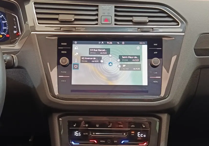 Vue rapprochée de la console centrale du Volkswagen Tiguan 2022, écran tactile de navigation et commandes climatisation.
