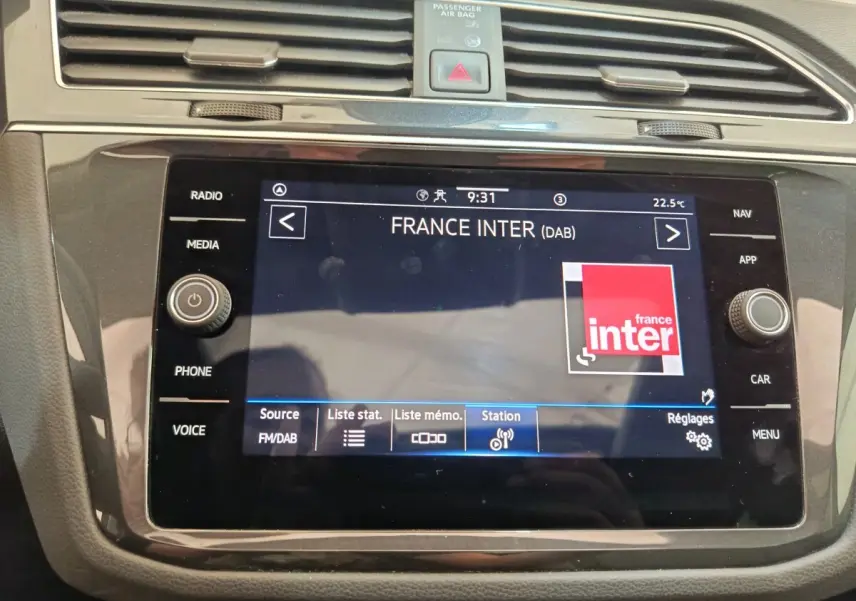 Vue rapprochée de l’écran tactile noir du système multimédia du Volkswagen Tiguan 2022 affichant la radio France Inter.
