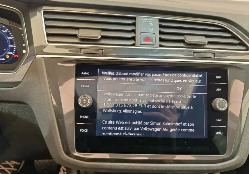Vue rapprochée de la console centrale du Volkswagen Tiguan 2022 noir, avec écran tactile affichant un message de confidentialité.