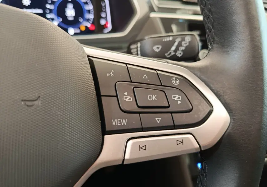 Gros plan sur les commandes multifonctions à droite du volant cuir noir du Volkswagen Tiguan 1.4 eHybrid 2022.