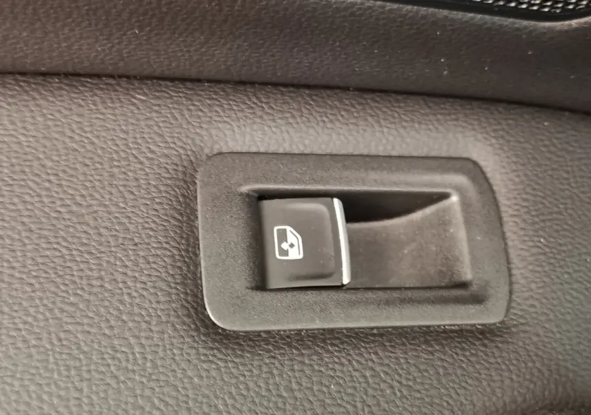 Gros plan sur bouton de commande électrique de vitre arrière dans l’habitacle noir du Volkswagen Tiguan 1.4 eHybrid 2022.