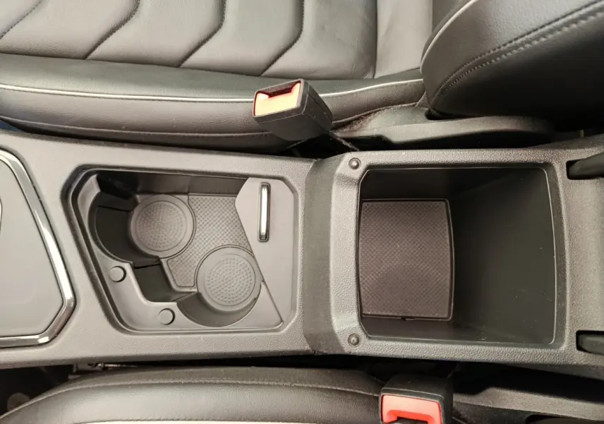 Vue plongeante sur le rangement central noir et porte-gobelets du Volkswagen Tiguan 1.4 eHybrid 2022.