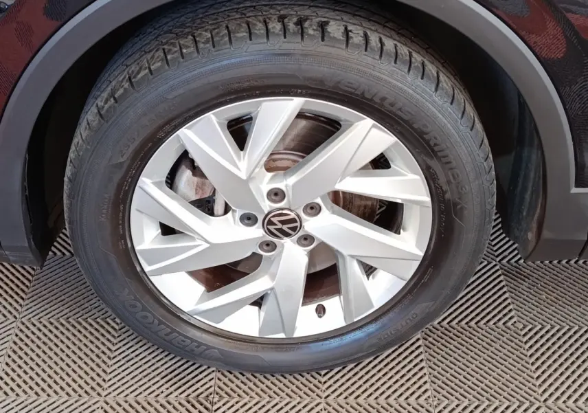 Gros plan sur la roue avant droite du Volkswagen Tiguan noir, mettant en valeur la jante alliage argentée à cinq branches doubles.