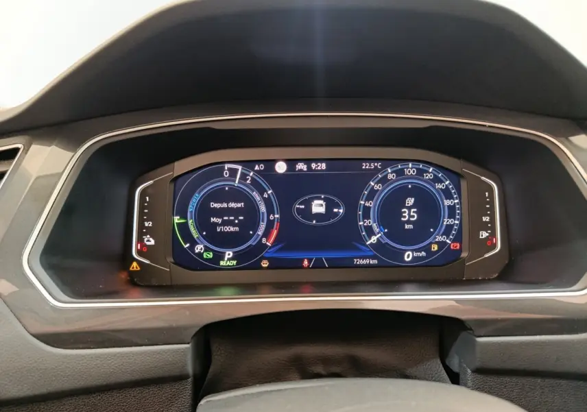 Tableau de bord numérique du Volkswagen Tiguan 1.4 eHybrid noir, affichage vitesse, autonomie et consommation.