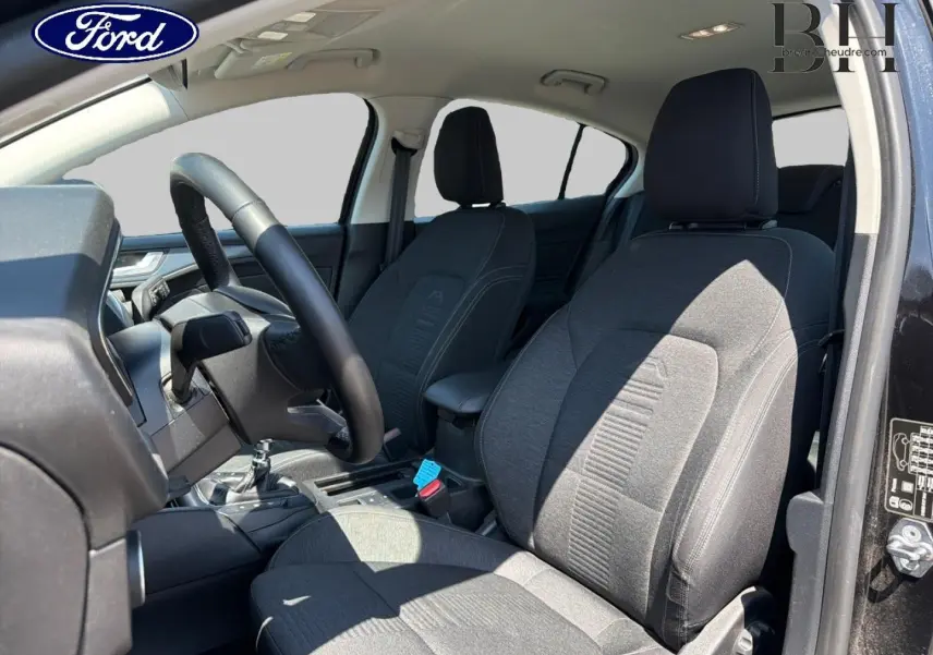 Vue intérieure côté conducteur de la Ford Focus 1.0 Flexifuel 2021 avec sièges tissu gris et volant cuir noir.