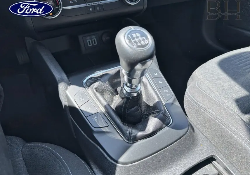 Le levier de vitesses manuel en cuir noir de la Ford Focus 1.0 Flexifuel, vue rapprochée de la console centrale.