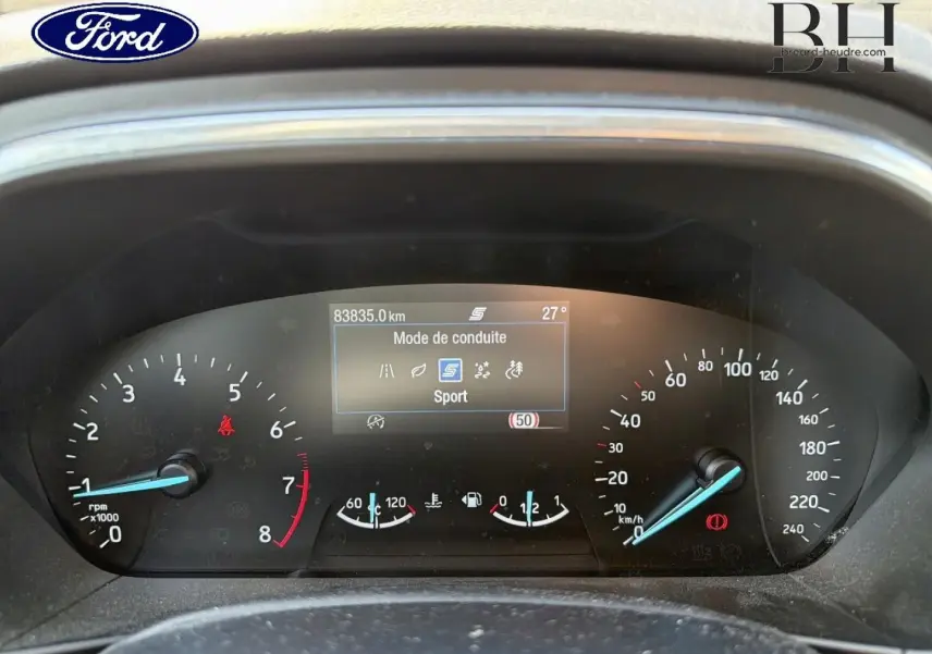 Tableau de bord de Ford Focus noir, vue frontale du combiné d'instruments avec affichage mode Sport et compteurs analogiques.