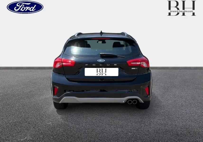 Vue arrière d'une Ford Focus noire Agate métallisé 2021 avec double sortie d'échappement et barres de toit visibles.