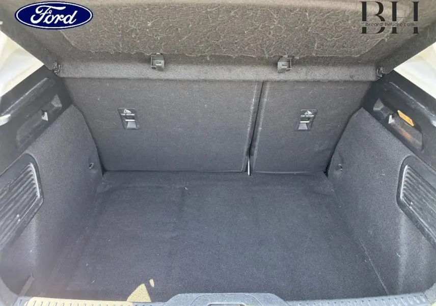 Vue intérieure du coffre spacieux et propre de la Ford Focus 2021, revêtement tissu noir uniforme.
