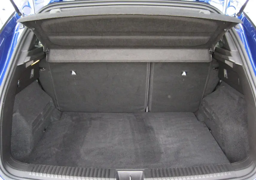 Coffre ouvert vu de l'arrière d'un Renault Austral bleu Iron, montrant l'espace de chargement vide et la tablette cache-bagages.