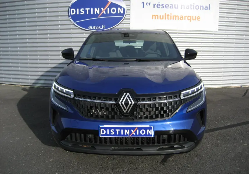Vue frontale d’un Renault Austral bleu Iron 2025 avec calandre noire et feux LED distinctifs allumés.