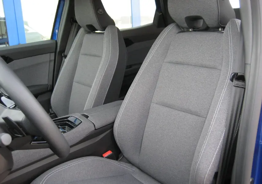 Vue intérieure côté conducteur du Renault Austral bleu Iron, mettant en valeur les sièges avant en tissu gris avec surpiqûres blanches.