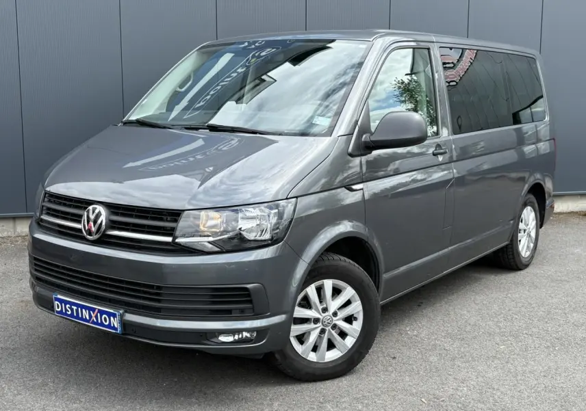 Vue 3/4 avant droit d'un Volkswagen Multivan T6 gris Indium avec jantes alliage et vitres teintées.