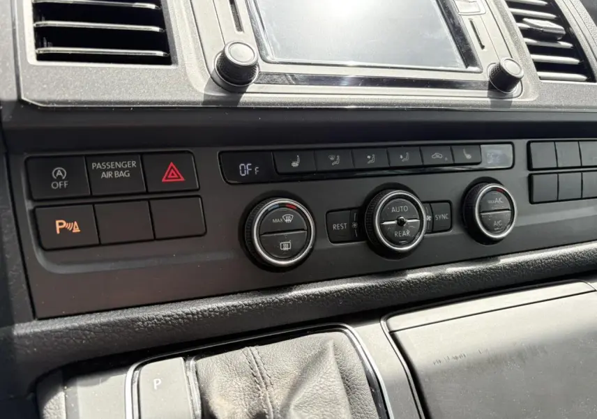 Vue rapprochée du tableau de bord et commandes de climatisation du Volkswagen Multivan T6 gris Indium de 2019.