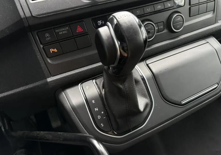 Gros plan sur le levier de vitesses DSG noir du Volkswagen Multivan T6 2.0 TDI 150 Trendline gris Indium de 2019.