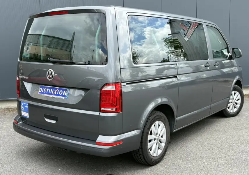 Vue 3/4 arrière droite d'un Volkswagen Multivan T6 gris Indium avec vitres teintées et jantes alliage léger.