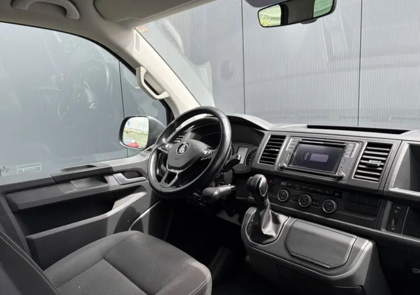 Intérieur avant du Volkswagen Multivan T6 gris Indium, volant cuir multifonction et console centrale avec écran tactile.