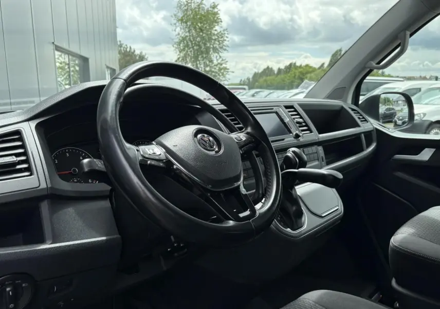 Intérieur du Volkswagen Multivan T6 gris Indium, vue côté conducteur sur le volant cuir multifonction et tableau de bord moderne.