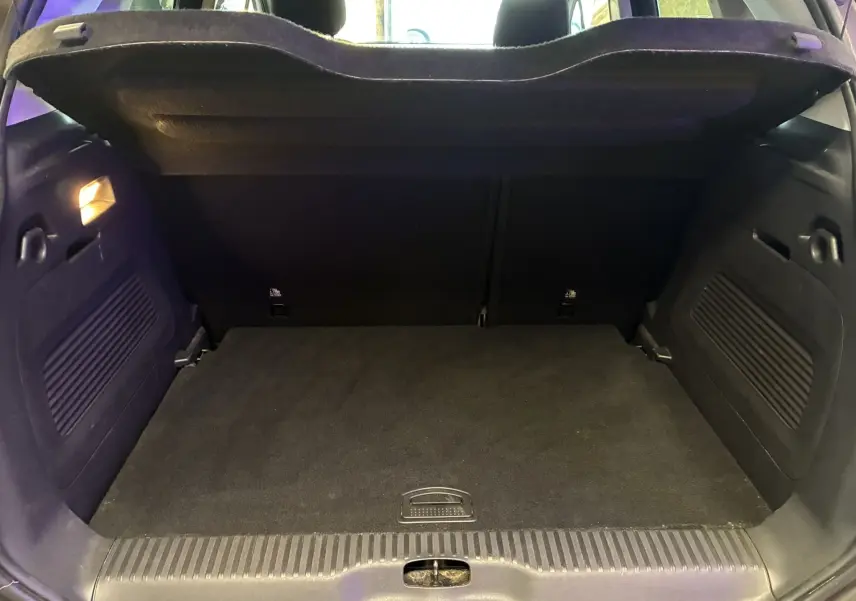 Coffre ouvert vu de l'arrière d'une Citroën C3 Aircross 2023, intérieur noir avec éclairage latéral allumé.