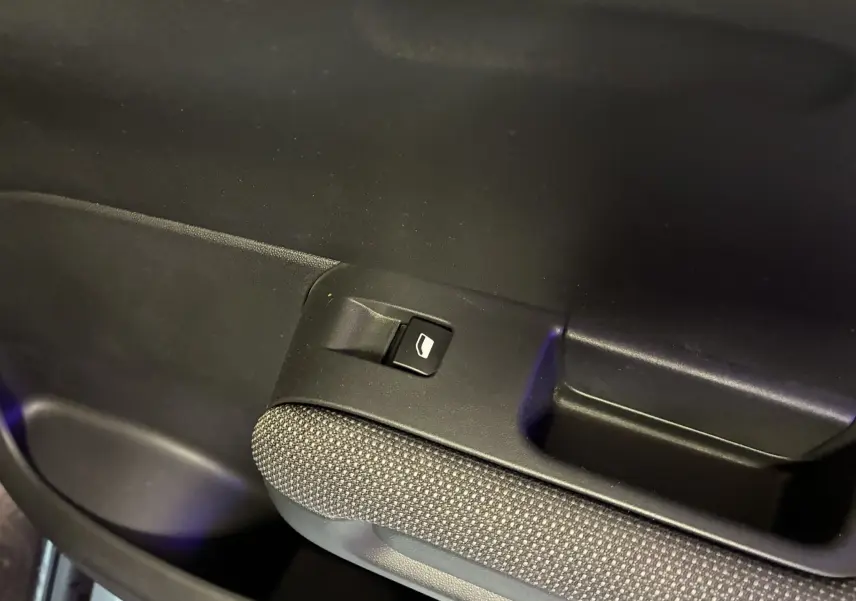 Gros plan sur le bouton de commande de la vitre électrique côté intérieur d'une Citroën C3 Aircross 2023 finition Shine.