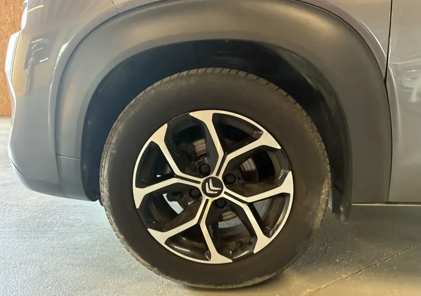 Gros plan sur la roue avant gauche du Citroën C3 Aircross gris platinium avec jante alu bi-ton 16 pouces.