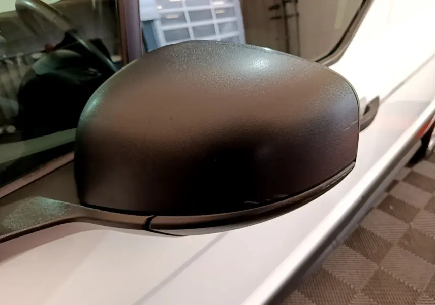 Rétroviseur noir côté gauche du Ford Transit Fourgon blanc, vue rapprochée sur la portière avant.