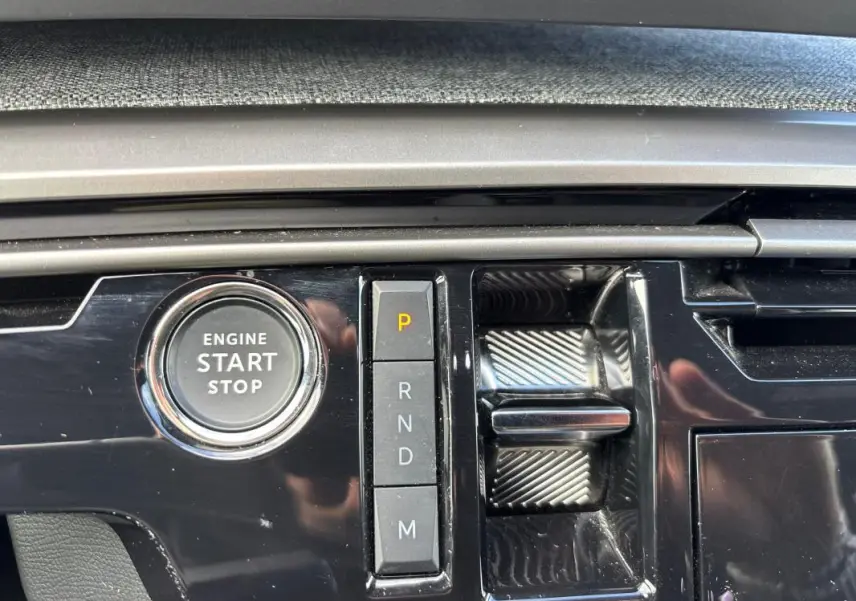 Gros plan sur la console centrale du Peugeot 3008 Hybrid gris, montrant le bouton start/stop et la sélection de vitesses automatique.