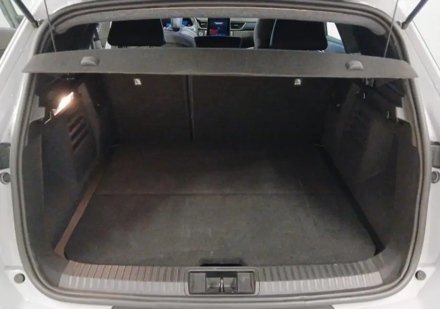 Coffre ouvert vu de l'arrière d'une Renault Symbioz gris clair, avec intérieur noir et tablette cache-bagages.