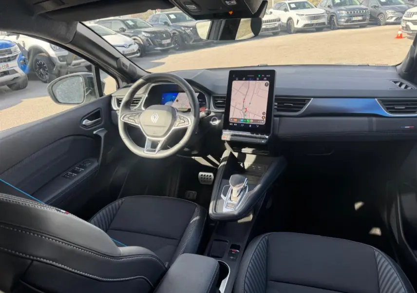 Vue intérieure avant gauche du Renault SYMBIOZ E-Tech gris clair, avec écran tactile vertical et volant multifonction.