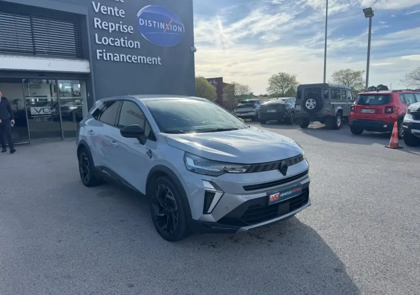 Renault Symbioz gris clair en 3/4 avant droit, jantes alliage noires et calandre moderne visible en extérieur.