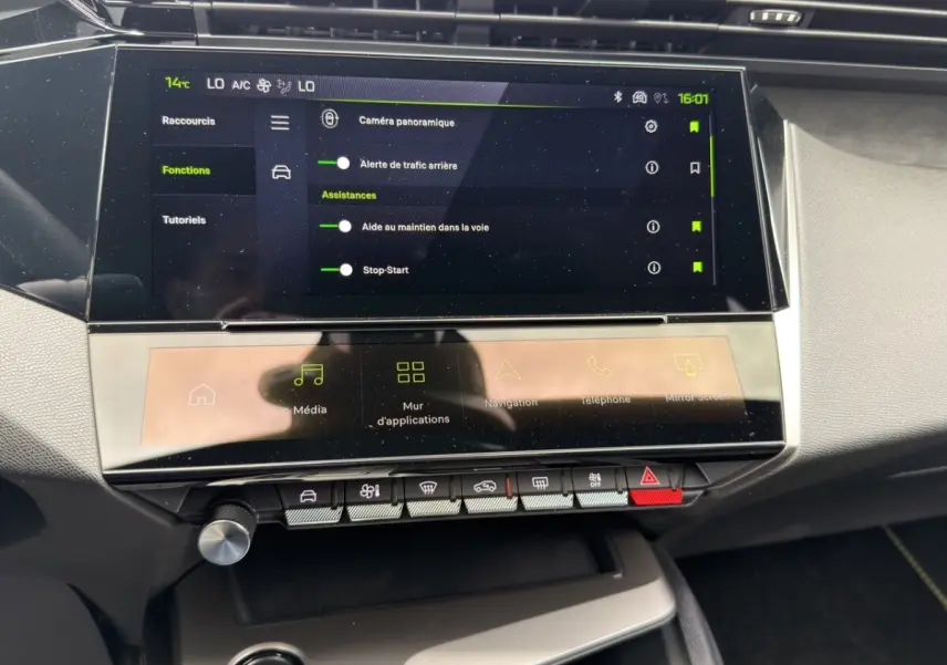 Vue rapprochée de l’écran tactile central et des commandes du tableau de bord intérieur d’une Peugeot 308 gris clair.
