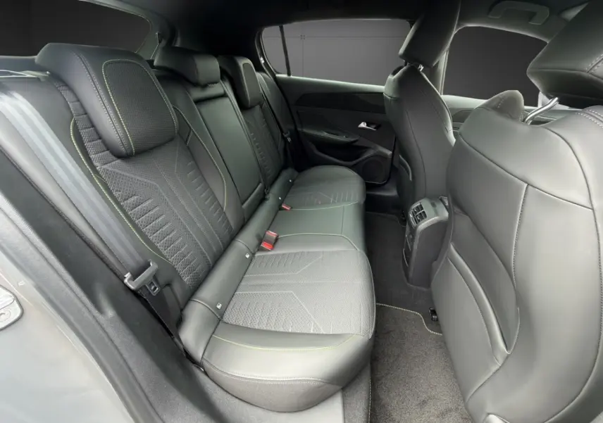 Vue intérieure arrière côté gauche de la Peugeot 308 gris clair, sièges en cuir et tissu avec surpiqûres contrastées.