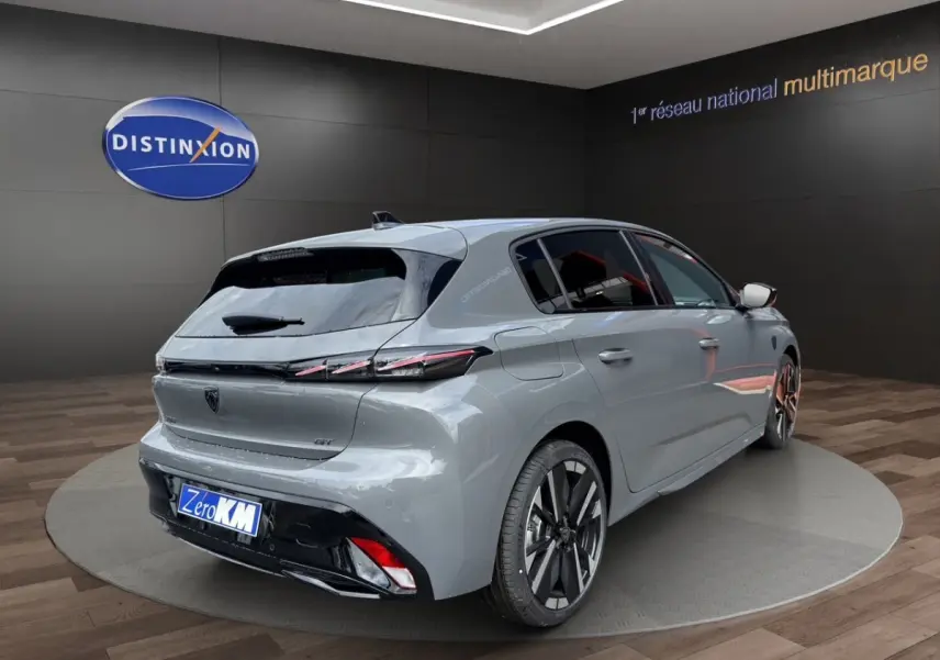 Vue 3/4 arrière droite d'une Peugeot 308 GT gris clair avec feux LED et jantes alliage bicolores.