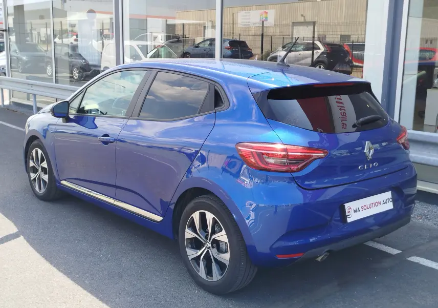 Vue 3/4 arrière droite d'une Renault Clio 1.0 SCe 65ch Evolution bleu Iron avec jantes alliage et vitres teintées.