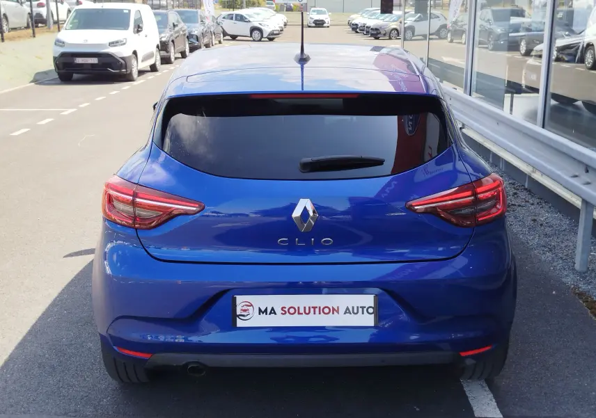 Vue arrière d'une Renault Clio 2022 Bleu Iron avec feux LED et vitre arrière teintée, stationnée en extérieur.