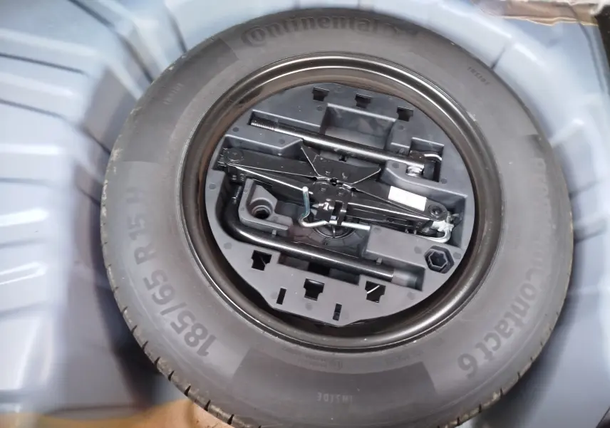 Roue de secours avec kit d'outils intégrés dans le coffre d'une Renault Clio bleu Iron 2022.