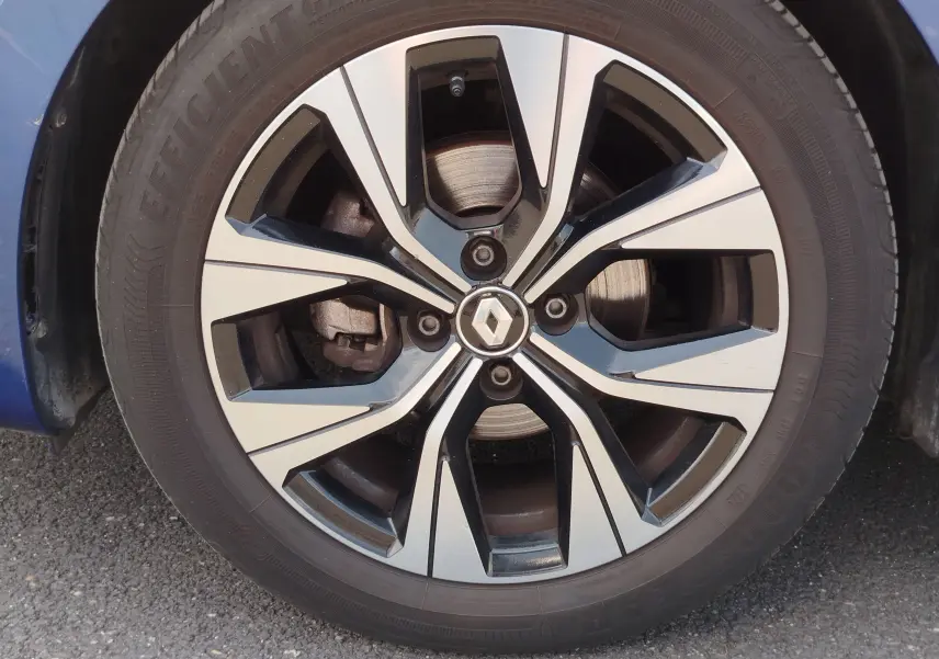 Gros plan sur la jante alliage bicolore noire et argentée de la Renault Clio Bleu Iron 2022, avec logo Renault central.