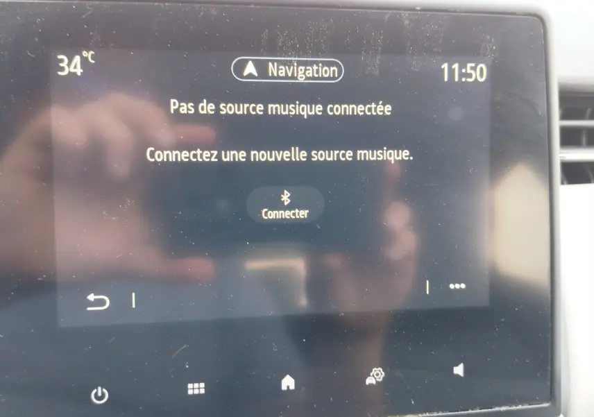 Écran tactile central de la Renault Clio 2022 affichant un message de connexion musicale, avec commandes tactiles visibles.